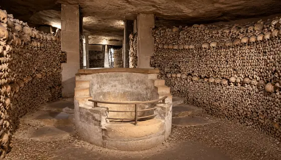 Fontaine de pierre entourée d’ossements dans les Catacombes de Paris